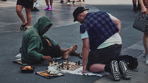 Two pedestrians playing chess on the ground