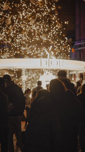 family stands in front of the christmas tree